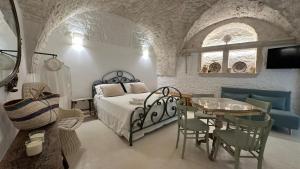 a bedroom with a bed and a table and chairs at La bottega di zia Tetta - Luxury Home in Ceglie Messapica