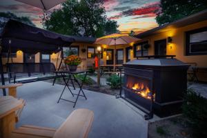 a backyard with a fireplace and a table and an umbrella at Adrian's Suites 2 Bedroom Family Suite in Wasaga Beach