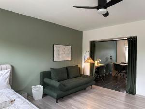 a living room with a green couch and a bedroom at LaCasa 03 Zentral,VW Nah,Top Ausstattung,Design in Wolfsburg
