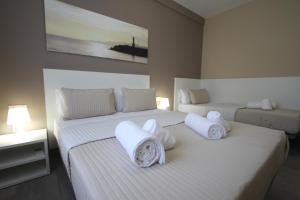 2 camas en un dormitorio con sábanas y almohadas blancas en Apartamentos Cambrils Playa Spa, en Cambrils