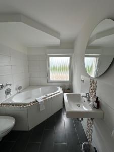 a bathroom with a tub and a sink and a mirror at LaCasa 03 Zentral,VW Nah,Top Ausstattung,Design in Wolfsburg