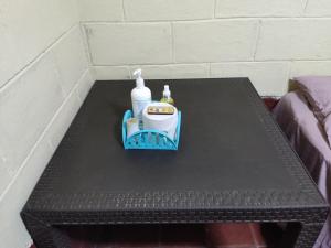 a black table with a bottle of soap and a detergent at KameHouse Backpackers in San Salvador