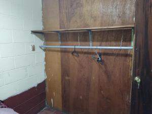 a wooden door with a pair of shoes on it at KameHouse Backpackers in San Salvador