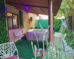 a bath tub sitting in the middle of a garden at Adac Boutique Hotel in Bucharest