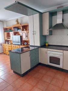 una cocina con armarios y electrodomésticos verdes y blancos en Alojamiento Sena VUT LE-1254, en Villablino