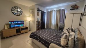 a bedroom with a bed and a clock on the wall at Comfy WalkUp Studio Near Mactan Airport -Perfect for Travellers in Lapu Lapu City +53 photos