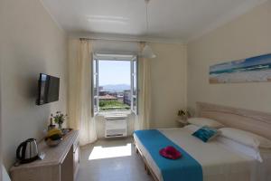Un dormitorio con una cama grande y una ventana en Brezza Marina Luxury Rooms, en Cagliari