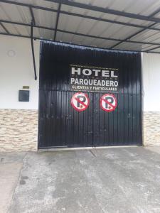 a black garage door with two signs on it at HOTEL EL VAQUIANO o FINCA ALTAMIRA in Estación El Salto
