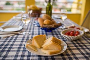 a table with a plate of cheese and grapes and glasses of wine at Apartment Vrbnik 1 in Vrbnik