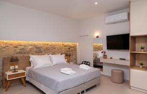 a hotel room with a bed and a television at HESTIA Studio Georgioupolis in Georgioupolis
