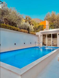 a large swimming pool in the middle of a house at Turkuaz Boutique Hotel in Sveti Stefan