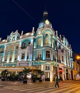 a large building with a clock on the top of it at Mid Ultra Central Apartments, Self Check In in Oradea
