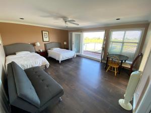 1 Schlafzimmer mit 2 Betten, einem Sofa und einem Tisch in der Unterkunft Vancouver Airport Blueberry Manor in Richmond