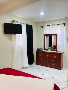 Un dormitorio con una cama y una cómoda con espejo. en De pina apartaestudio, en Santiago de los Caballeros