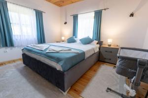 a bedroom with a large bed with blue curtains at Kula 1960 Luxury Stone House in Rožaje +40 photos