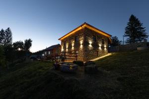 a stone building with lights on it in a field at Kula 1960 Luxury Stone House in Rožaje