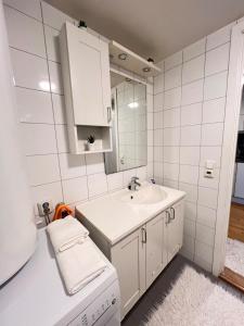 un bagno bianco con lavandino e specchio di Appartment a Grorud Altre 21 foto
