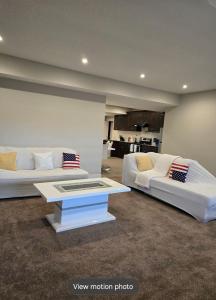 a living room with two white beds and a table at Golden Acreage Getaway 2 Bedroom in Balzac