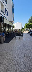 Un grupo de personas sentadas en bancos frente a un edificio. en Appartement hory, en Martil