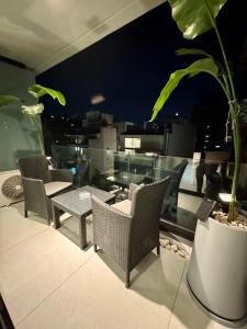 a balcony with chairs and a table and a plant at Foster Studio - Park in Buenos Aires