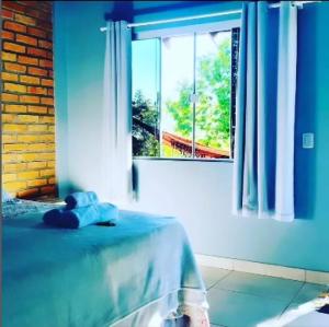a blue room with a bed and a window at Pousada Floradas da Serra in Chapada dos Guimarães +14 photos
