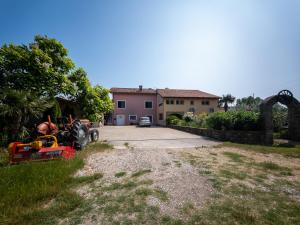 a house with a tractor parked in front of a driveway at LUNA APARTMENTS Quiet Retreat, Close to Koper, AirCon, Parking in Ankaran