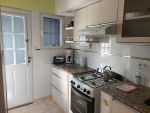 a kitchen with a stove top oven next to a window at Casa de Cande in Tandil
