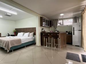 a large bedroom with a bed and a kitchen at SUITE PREMIUM central in Brusque