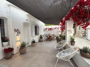 a patio with chairs and a table and flowers at Mellow Paros in Parikia