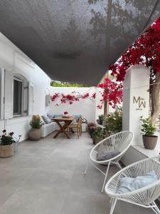 a patio with a table and chairs and red flowers at Mellow Paros in Parikia +52 photos