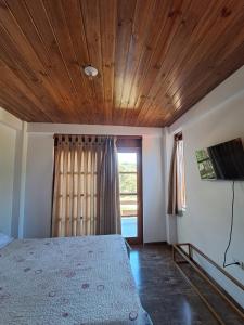 a bedroom with a bed and a wooden ceiling at Bellavista Hospedaje in Oxapampa