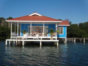 a blue house on a dock on the water at Paraiso Escondido in Bocas Town