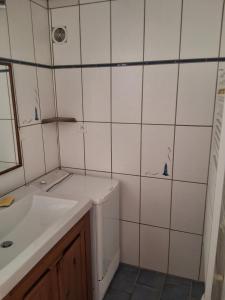 ein weißes Badezimmer mit Waschbecken und Spiegel in der Unterkunft Noirmoutier house 6 to 8 people in Noirmoutier-en-l'lle