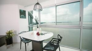 a white table and chairs in a room with a large window at Suite 7 Riverfront 1, Puerto Santa Ana, Guayaquil in Guayaquil