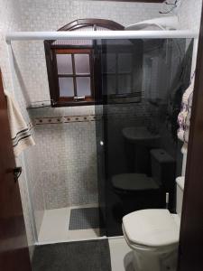 a bathroom with a shower with a toilet and a sink at Casa Florânia, Campos do Jordão in Campos do Jordão