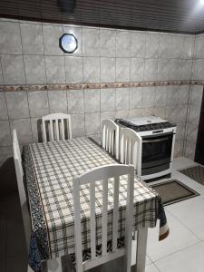 a kitchen with two chairs and a table and a stove at Casa Florânia, Campos do Jordão in Campos do Jordão