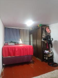 a bedroom with a bed with a red blanket and a table at Ap COP 30 NA AUGUSTO MONTENEGRO in Belém