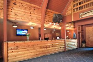 a lobby with a large wooden wall with a bar at Kohl's Ranch Lodge in Payson