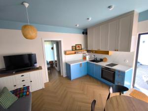 a kitchen with blue and white cabinets and a table at Apartament pod Zefirem in Tupadła