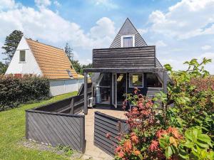 a small house with a gambrel roof in a yard at 4 person holiday home in Gedser in Gedser