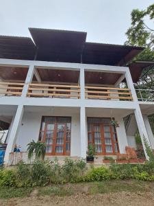a white house with a black roof at Bellavista Hospedaje Vista asombrosa in Oxapampa