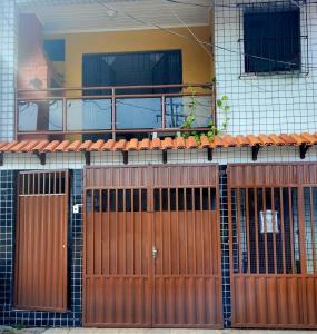 a house with brown doors and a balcony at Entire home COP 30 next to Hangar in Belém