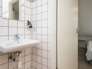 a white bathroom with a sink and a mirror at 2-room apartment in Denmark in Ringkøbing