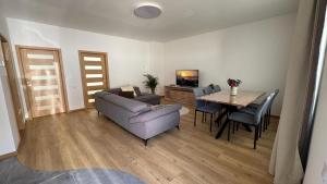 a living room with a couch and a table with chairs at Apartment Andi Parndorf in Parndorf