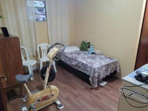 a small room with a bed and a moped in it at Entire home COP 30 next to Hangar in Belém