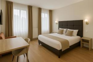 a hotel room with a large bed and a table at Thoiry Etoile Lodge, Sure Hotel Collection by Best Western in Thoiry +21 photos