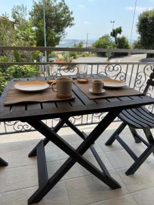 a wooden table with plates and cups on a balcony at Belvedere MareMonti in Belvedere Ostrense
