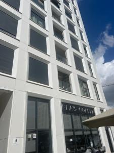 a tall white building with a lot of windows at Shehu Apartments in Tirana