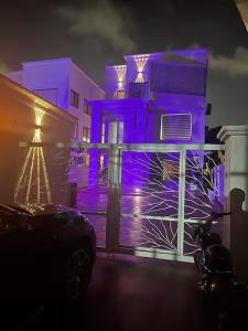 a building with purple lights on the side of it at Beautiful Bedroom Apartment Near Accra Mall Guest Favorite in Accra