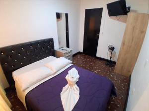 a bedroom with a purple bed with a headboard at Hostal las vegas Malaga in Estación El Salto +17 photos